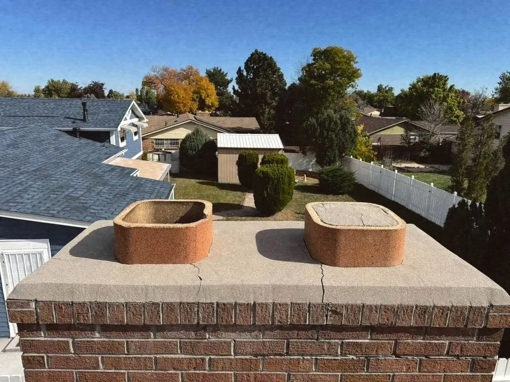 Two clay flue tiles on a cracked chimney crown
